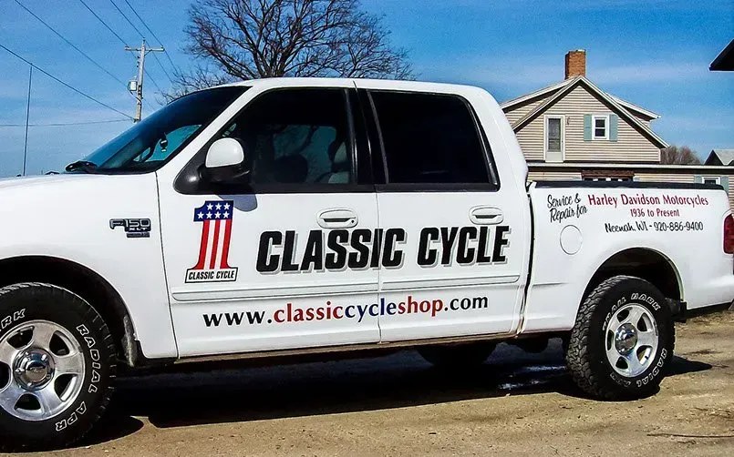 A classic cycle truck is parked in front of a house