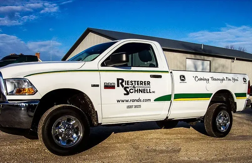 A white truck is parked in front of a building.
