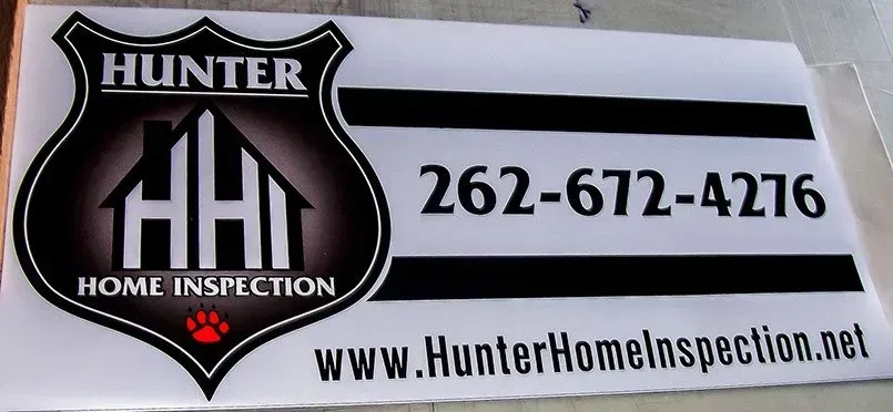 A sign for hunter home inspection with a phone number