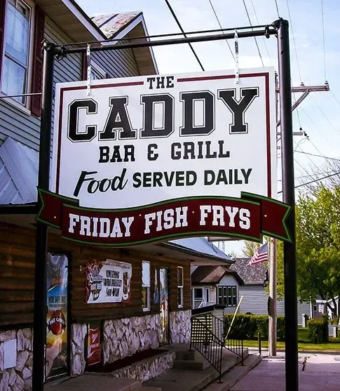 A sign for the caddy bar and grill says friday fish frys