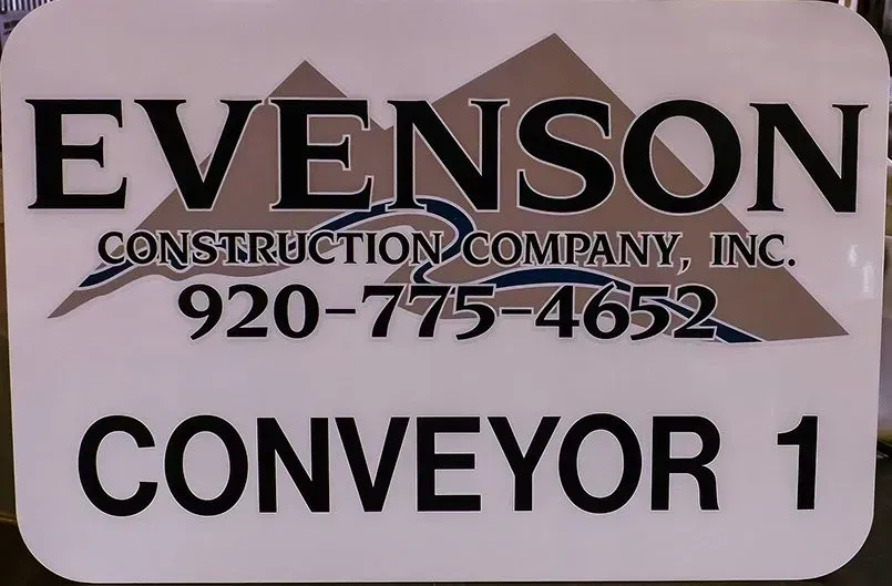 A sign for evenson construction company inc. says conveyor 1