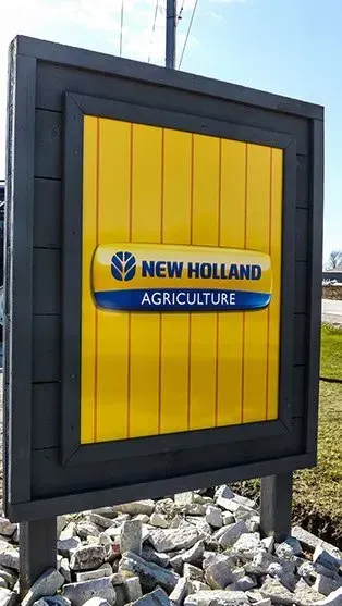 A yellow sign that says new holland agriculture on it
