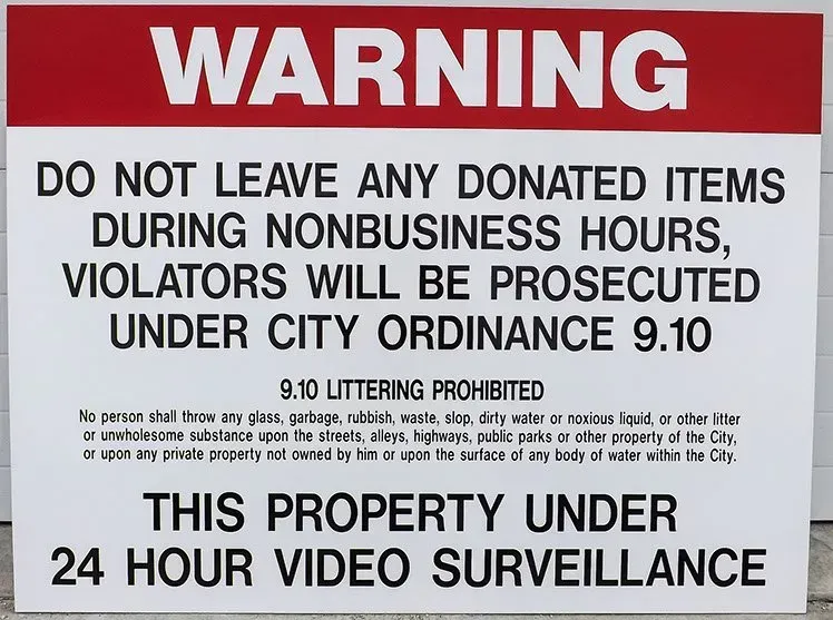 A warning sign that says do not leave any donated items during nonbusiness hours
