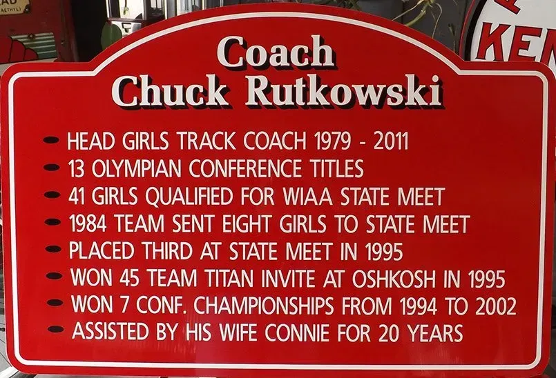 A red sign that says coach chuck rutkowski on it