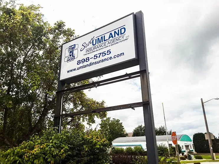 A blue and white sign for umland insurance company