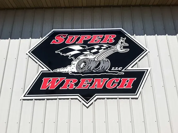 A super wrench sign hangs on the side of a building
