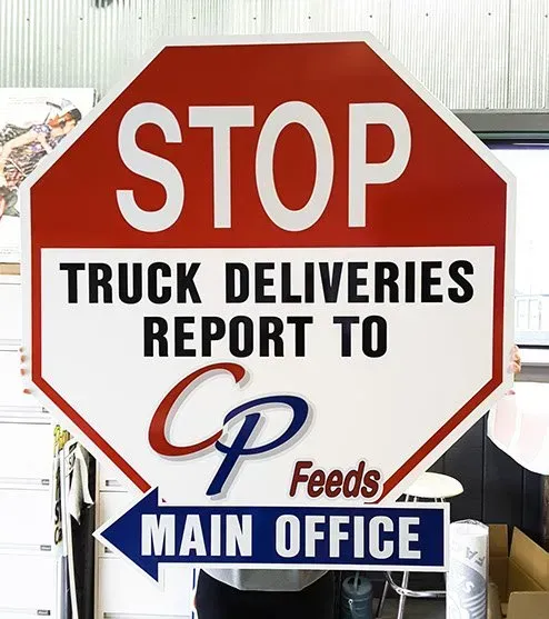 A stop sign that says truck deliveries report to cp feeds main office