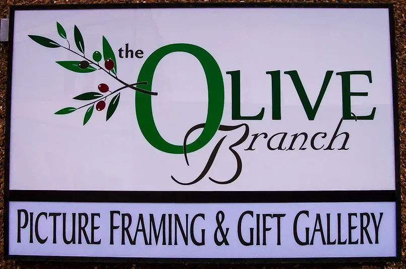 A sign for the olive branch picture framing and gift gallery