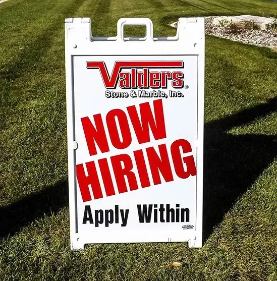 A sign that says ' now hiring apply within ' on it