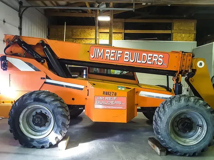 A jim reif builders tractor is parked in a garage