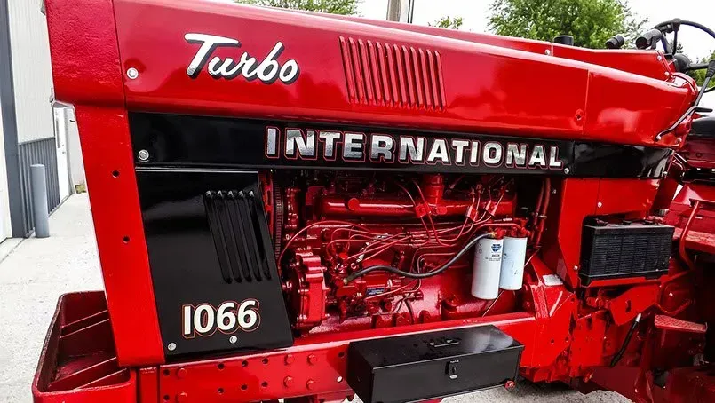 A red international turbo 1066 tractor is parked on the side of the road.