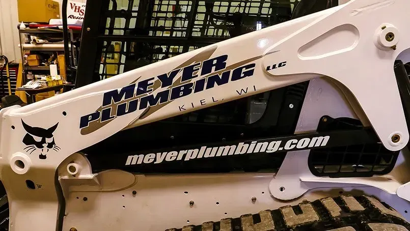 A bobcat with meyer plumbing written on it