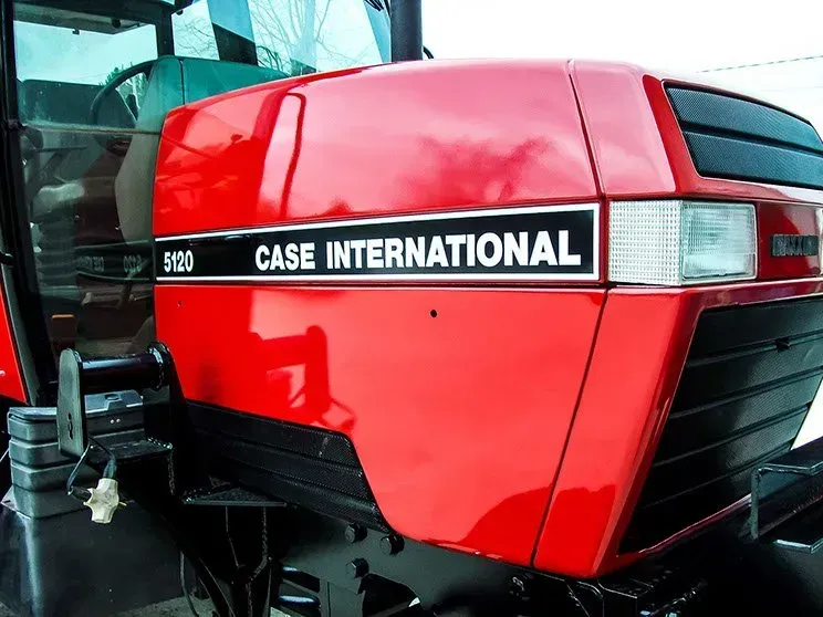 A red case international tractor is parked in a parking lot