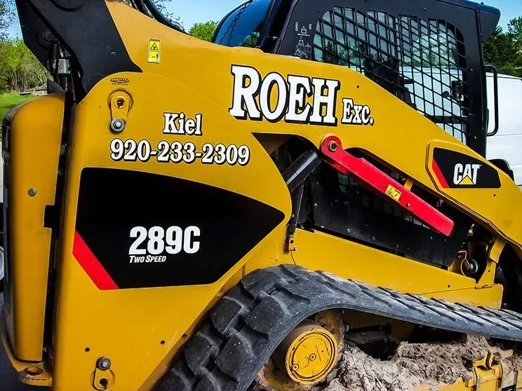 A yellow and black tractor with the word roeh on it
