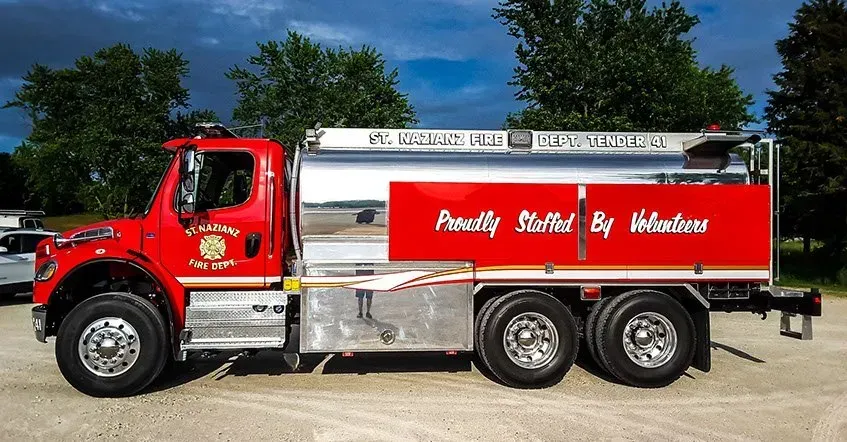A red truck with the words proudly staffed by members on the side