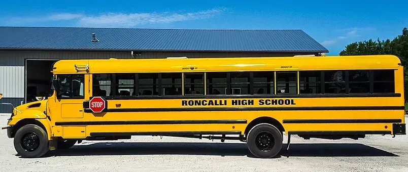 A yellow school bus is parked in front of a building.