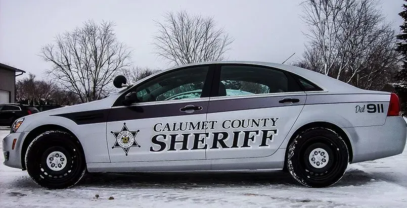 A calumet county sheriff car is parked in the snow