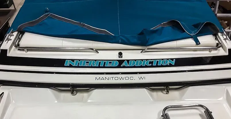 A white boat with a blue cover on top of it