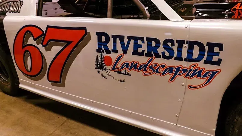 A white race car with riverside landscaping written on the side