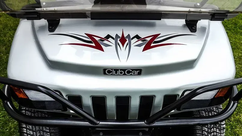 The front of a silver club car with a tribal design on it