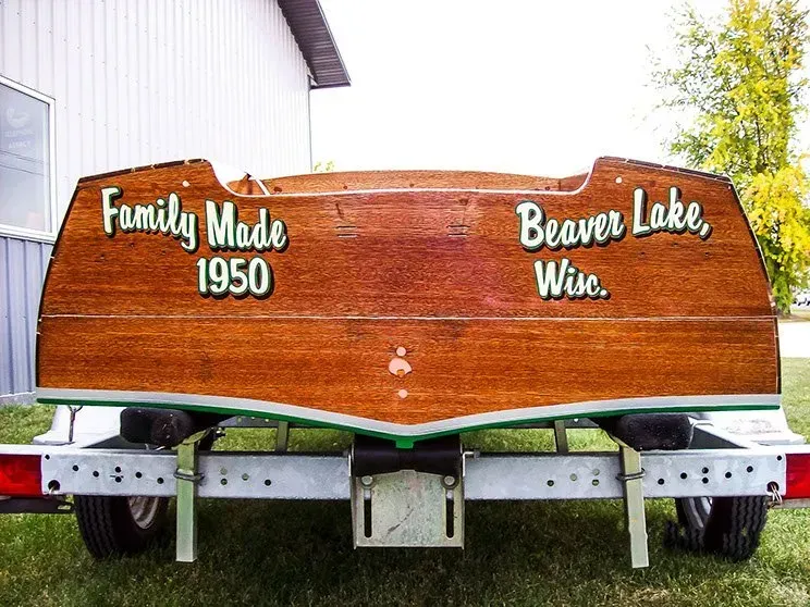 A wooden boat on a trailer that says family made 1950 beaver lake wise