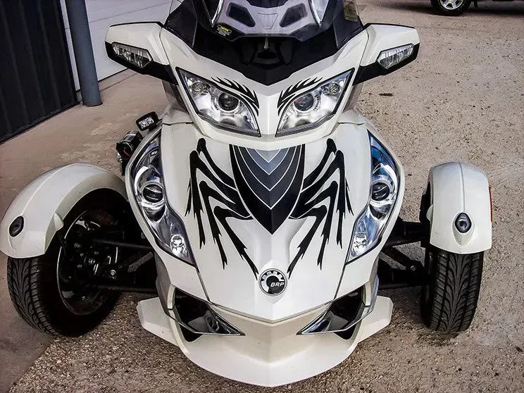 A white motorcycle with a spider design on the front