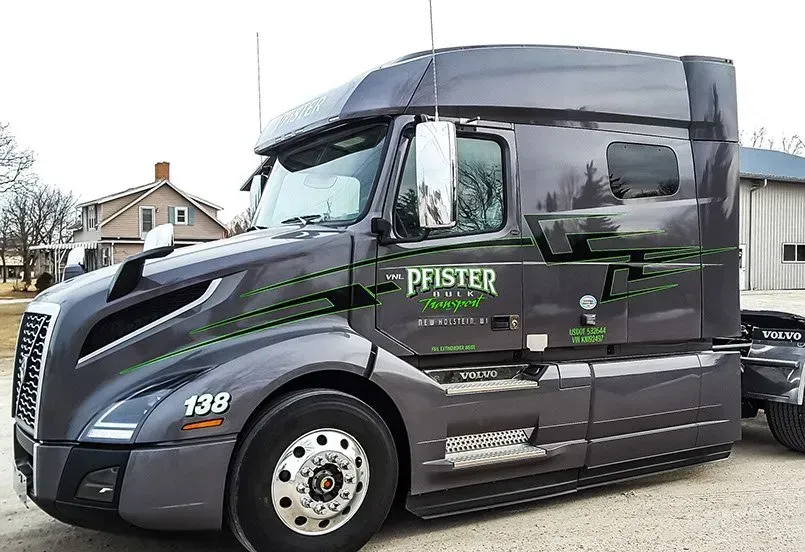A large semi truck is parked in front of a building.