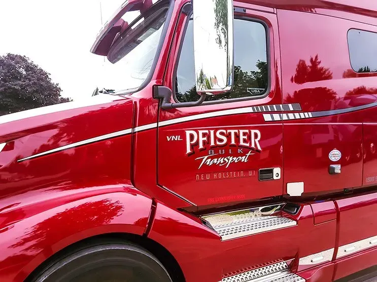 A red pfister truck is parked on the side of the road