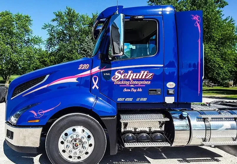 A blue schulz semi truck is parked in a parking lot