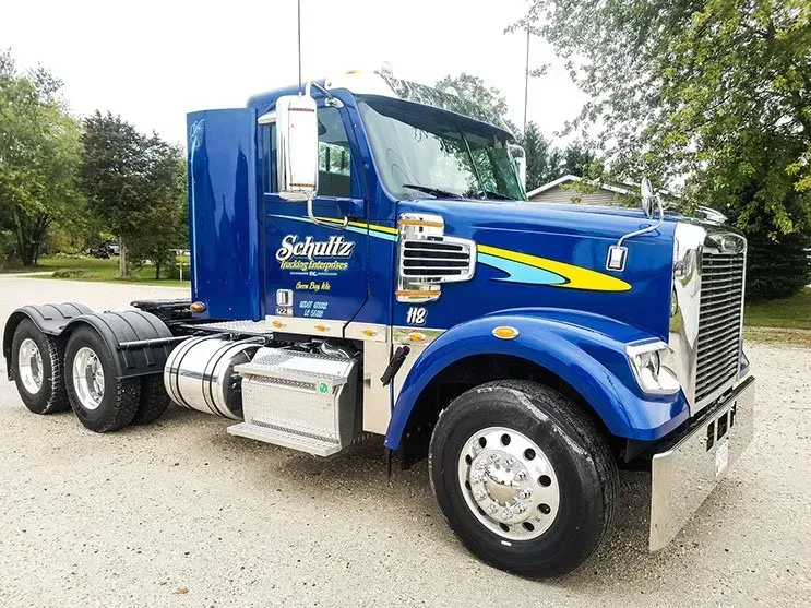 A blue semi truck is parked on the side of the road.