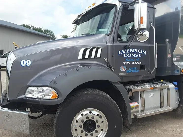 A gray truck with the number 09 on the side is parked in a parking lot.