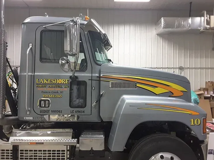 A large gray semi truck is parked in a garage.