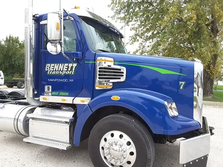 A blue bennett semi truck is parked on the side of the road