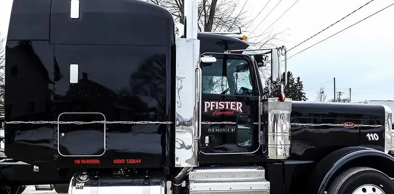 A black semi truck is parked on the side of the road.