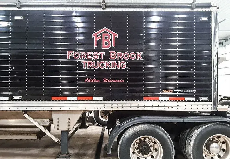 A forest brook trucking trailer is parked in a garage