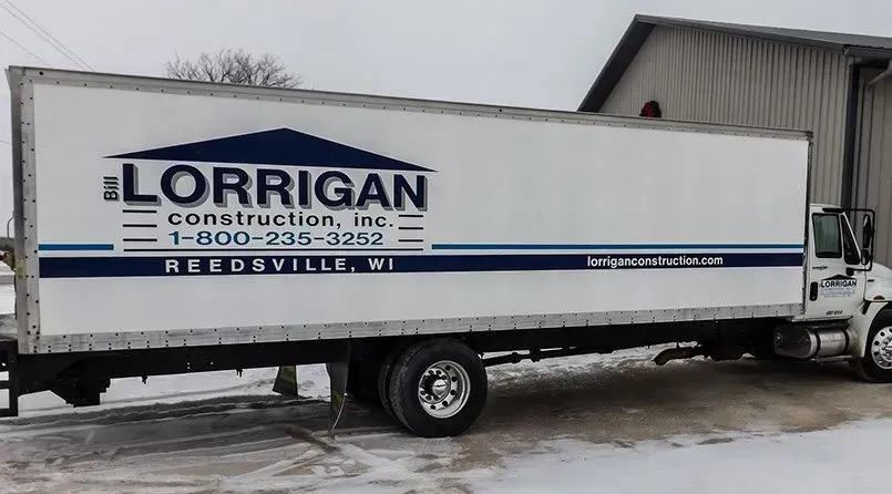 A lorrigan construction truck is parked in the snow
