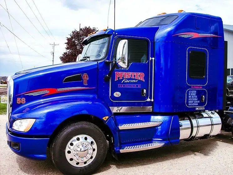 A blue semi truck is parked on the side of the road.