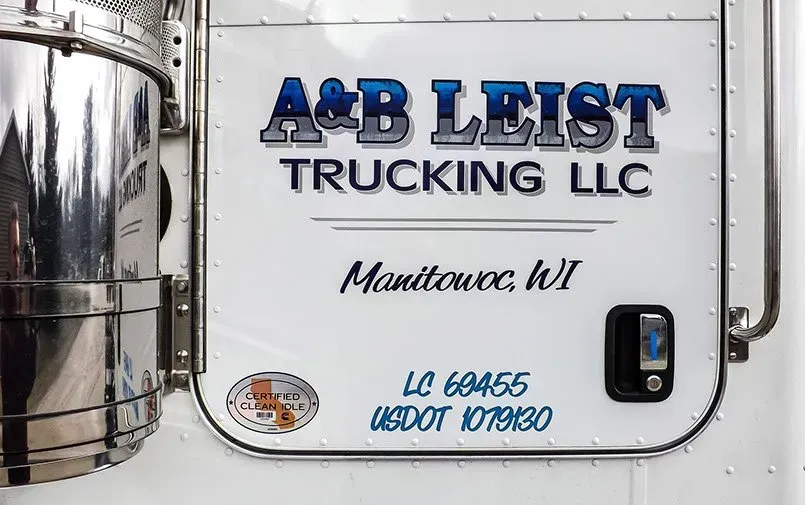 A white truck with a sign that says ab leist trucking llc