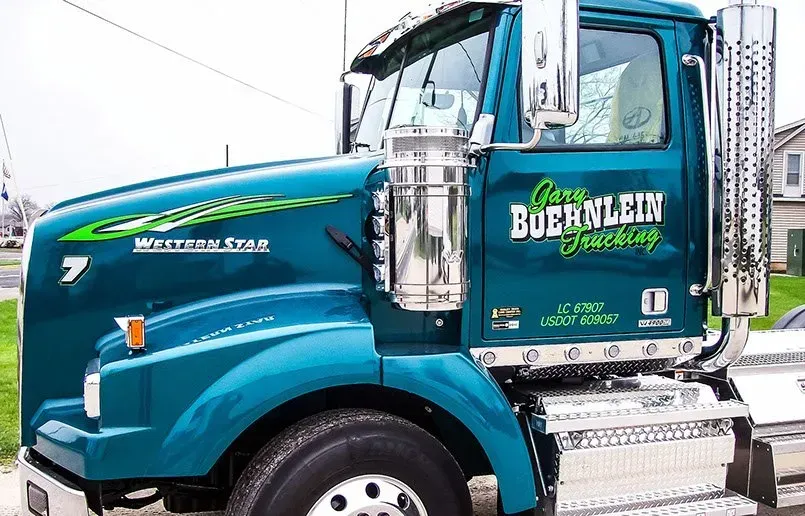 A blue buernlein truck is parked on the side of the road