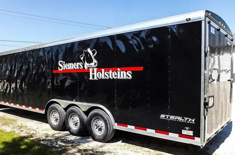 A black trailer with the word holsteins on it