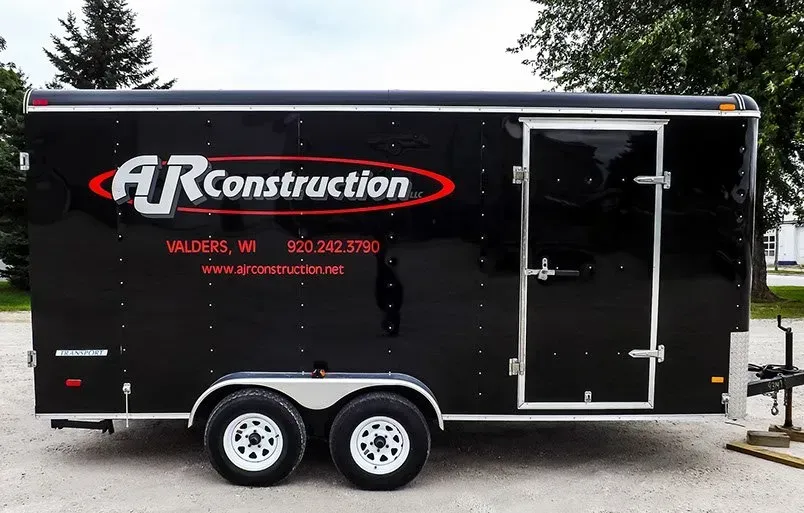 A black trailer that says ar construction on it