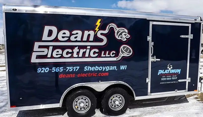 A trailer for dean 's electric llc is parked in the snow