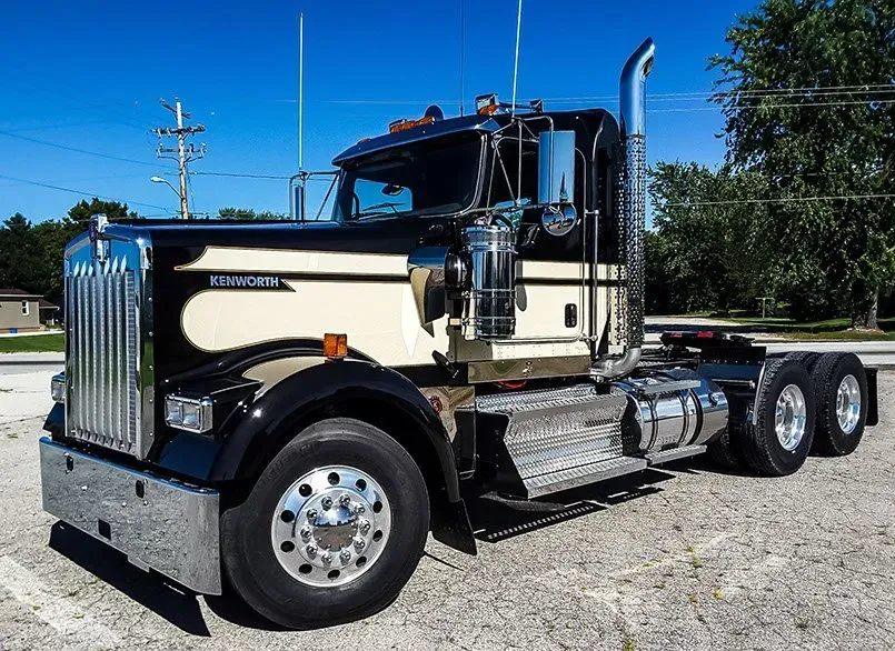 A black and white semi truck is parked in a parking lot.