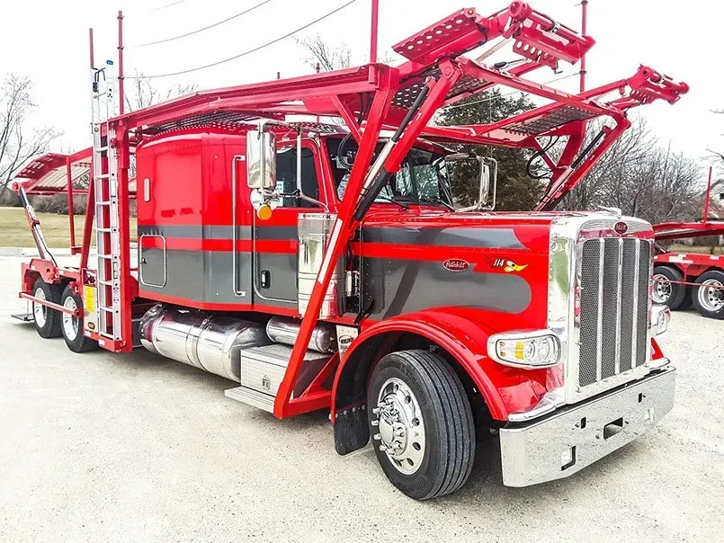 A red semi truck with a trailer attached to it is parked in a parking lot.