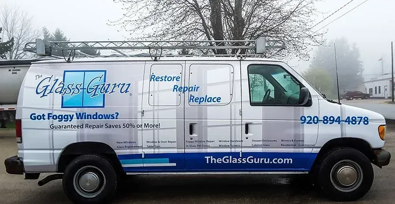 A glass guru van is parked on the side of the road
