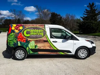 A canteen catering van is parked on a dirt road