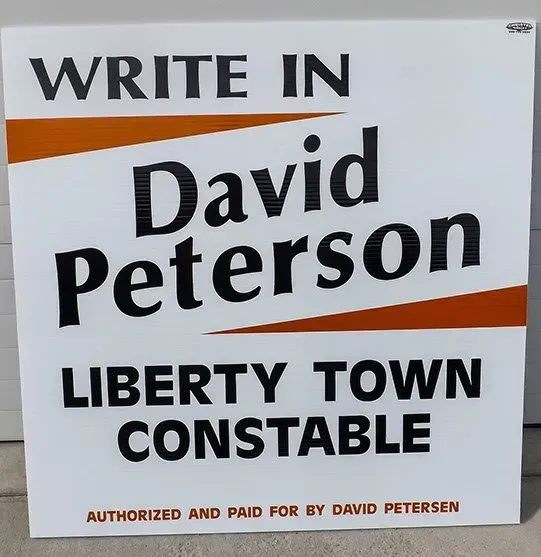 A sign that says write in david peterson liberty town constable