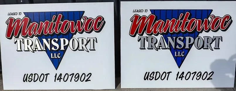 Two signs for manitoba transport llc are sitting next to each other