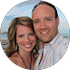 A man and a woman are posing for a picture on the beach.