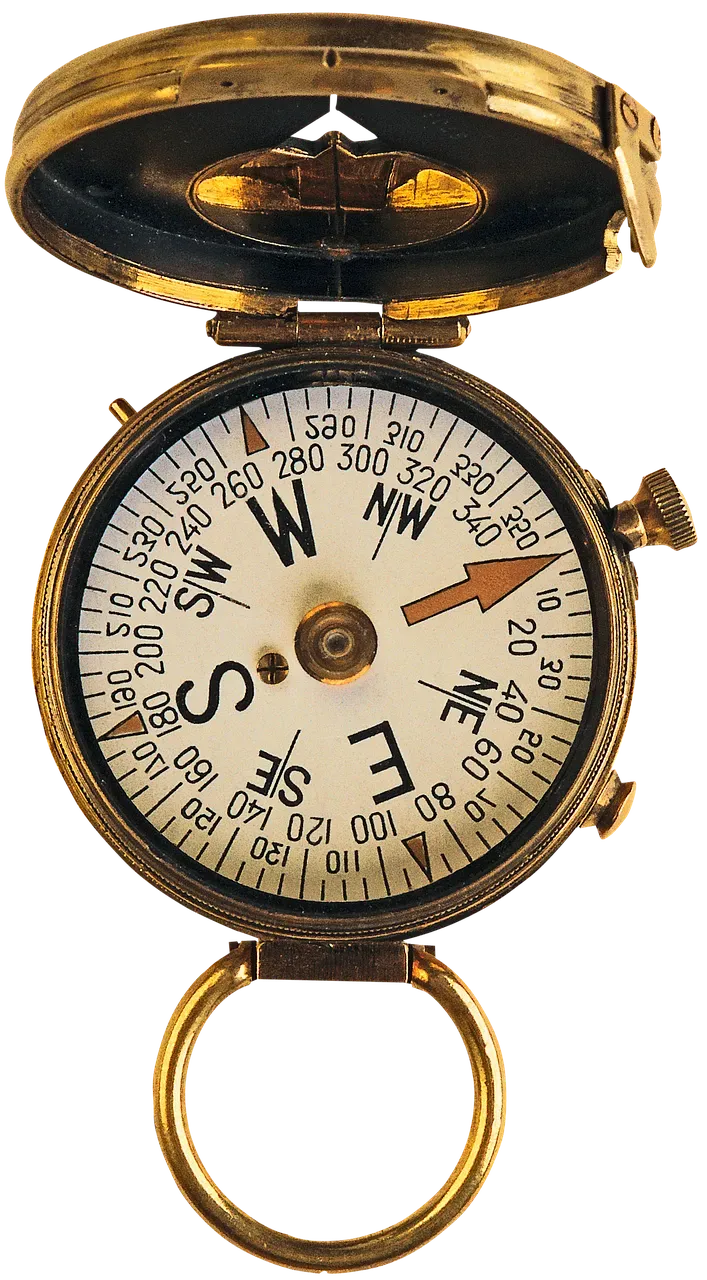 Antique brass compass, open, showing dial with arrow pointing east.
